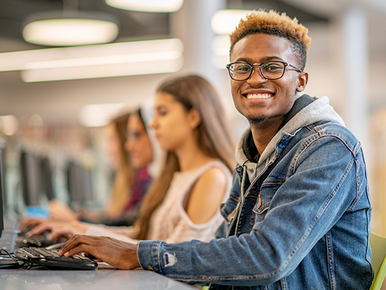 Image of student typing and smiling
