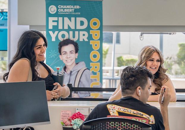 New Students two female at the admissions office with a male clerck
